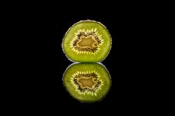 Fresh green kiwi fruit slice in dark studio