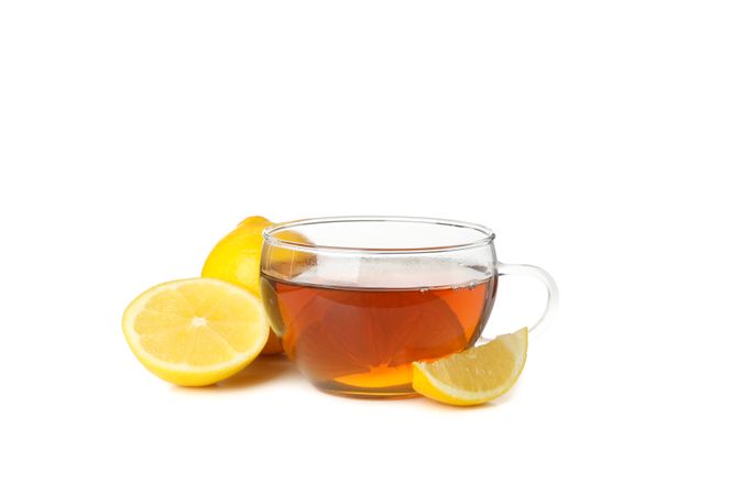 Tea and lemon slices isolated on bright background