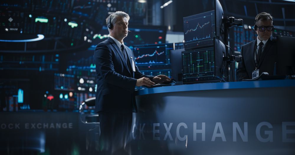 Handsome Stock Exchange Trader Following a Live Auction, Communicating Buy and Sell Orders to Operator on the Other Side of the Call.