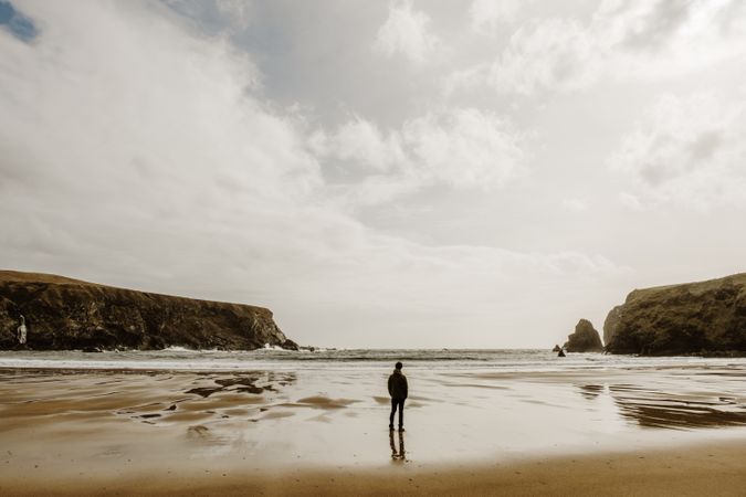 Back view of man standing on seashore in Ireland