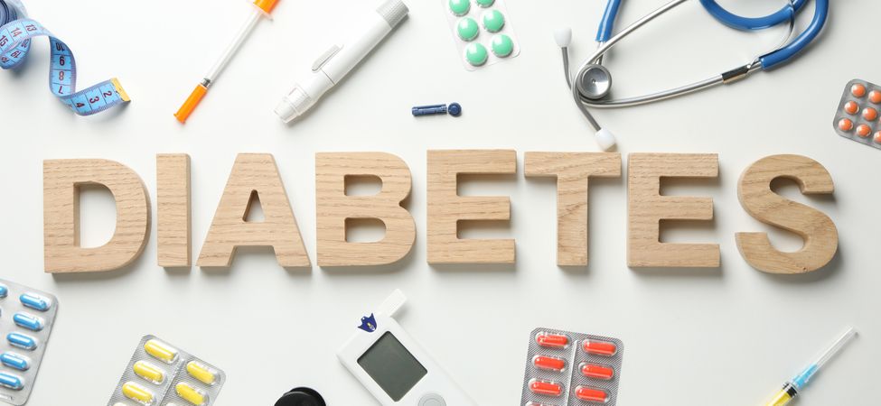 Word Diabetes made of wooden letters on blank  background. Diabetes accessories