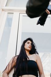 Crop photographer taking pictures of young model