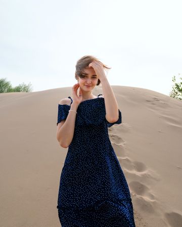 Woman in dress posing  on sandy dunes