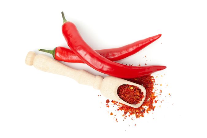 Scoop with spice and chilli peppers isolated on blank background