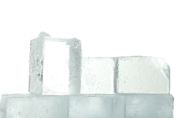 Close up of clear square ice cubes stacked in bright room