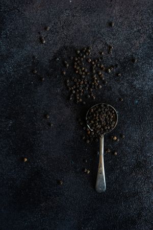 Measurement spoon filled with peppercorns