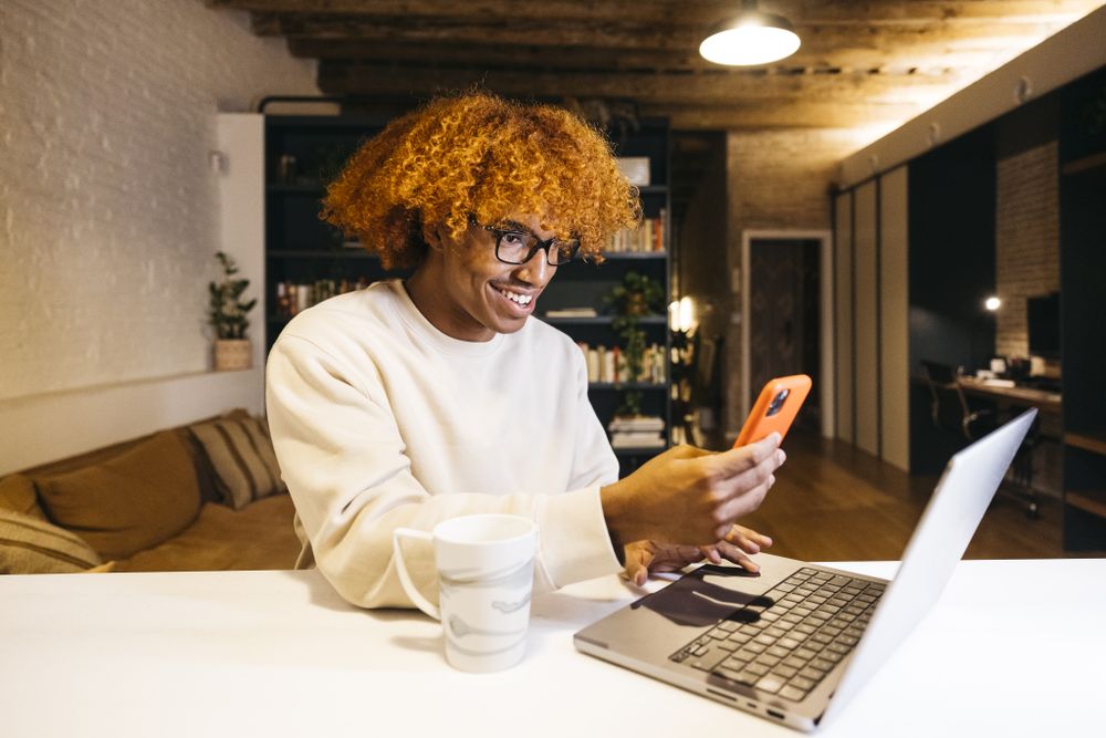 Young man using phone at home.