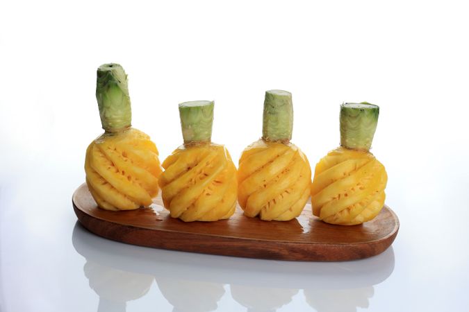 Four Peeled Pinapple Nanas Madu Pemalang on Wooden Plate