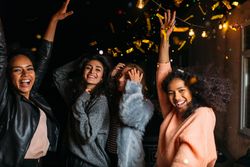 Multi-ethnic group of stylish women celebrating at night