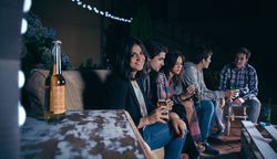 Woman holding beer with her friends talking in a party