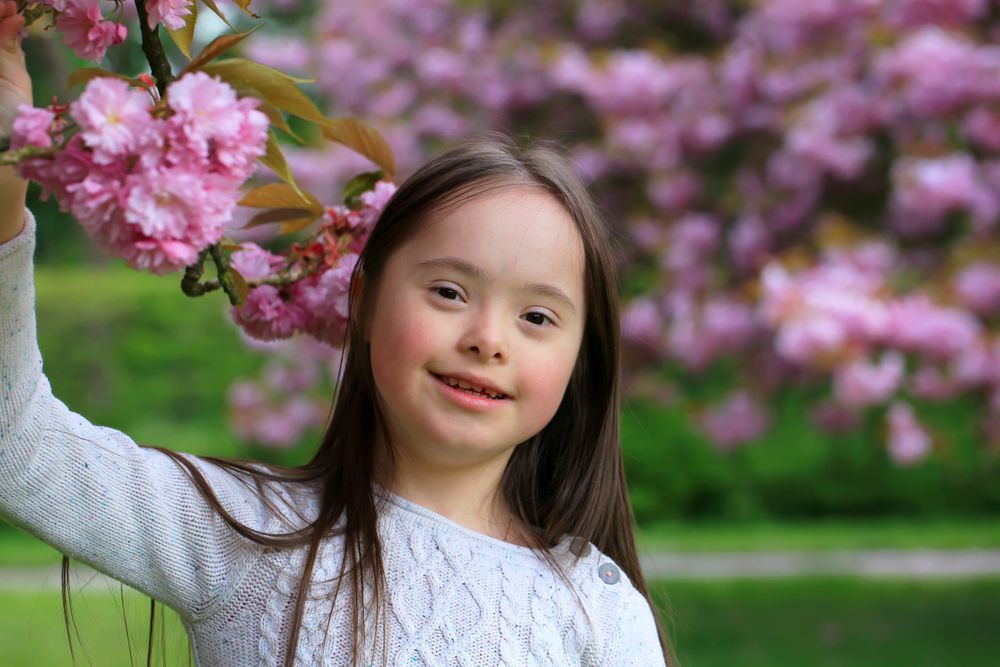 Portrait of young girl standing next to floral tree