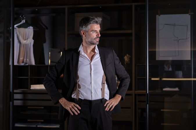 Mature businessman in suit standing at home
