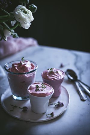 tasty glasses of strawberry mousse on a table with flowers
