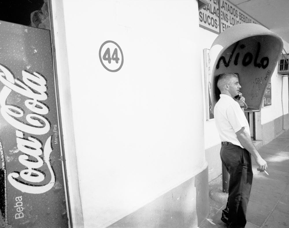 Porto Alegre, Brazil - Jan 28, 2005 - Man smoking while using payphone