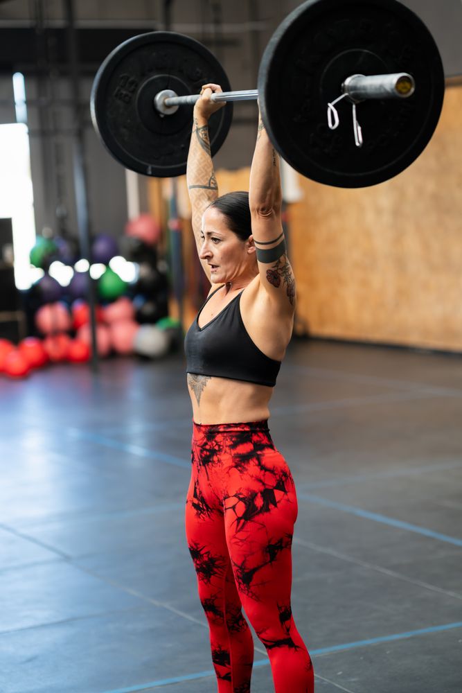 Sporty woman lifting weights alone in a gym