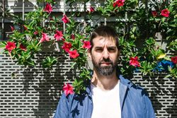 Man standing outside in front of floral wall