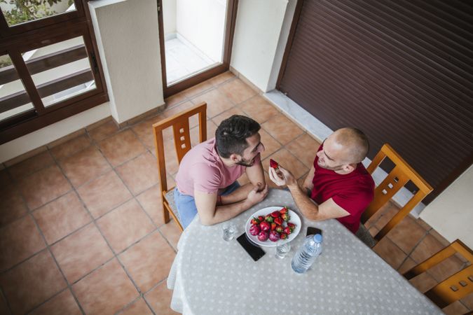 Gay couple eating strawberries