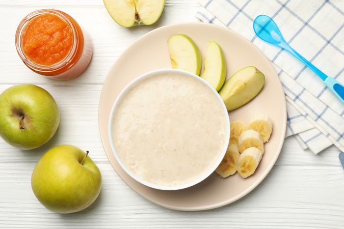 Composition with baby food on plain wooden background