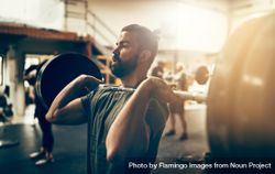 Focused man holding heavy barbell on shoulders 4Mzpyb