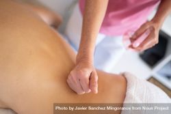 Masseuse massaging lower back of woman in spa salon 5wXjGm