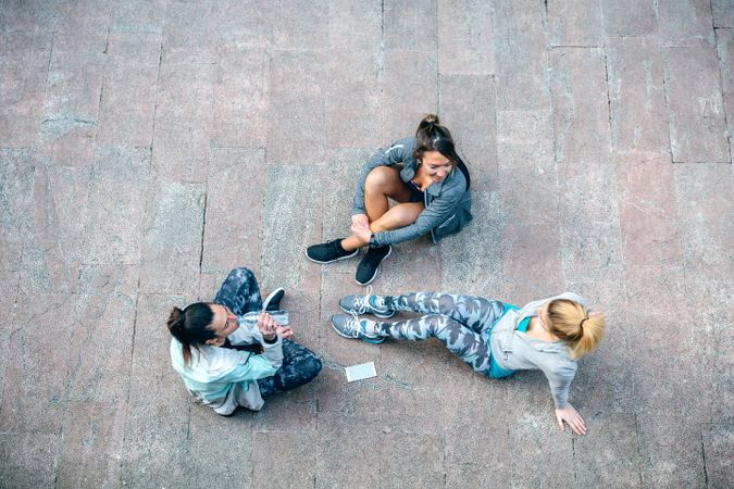 Female friends sitting on the ground after training