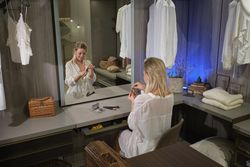 Woman sitting at dressing table and holding perfume