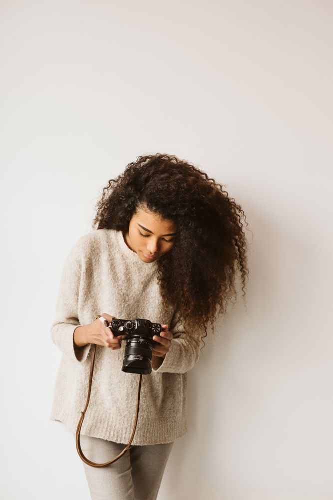 Cheerful Black woman with camera