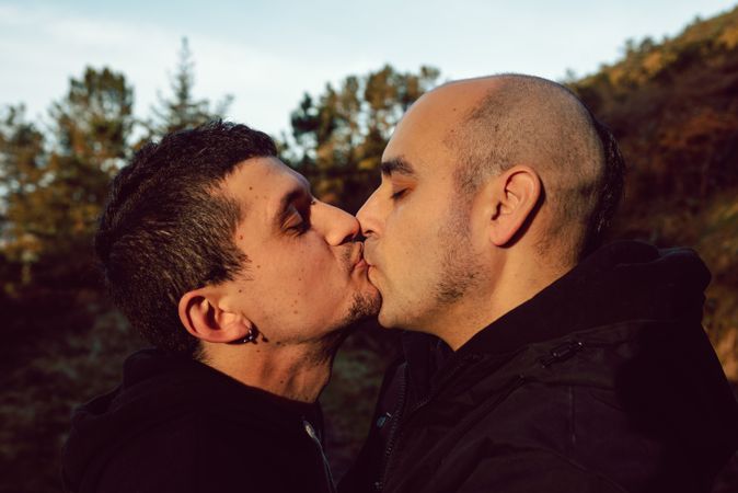 Men hugging and kissing in park