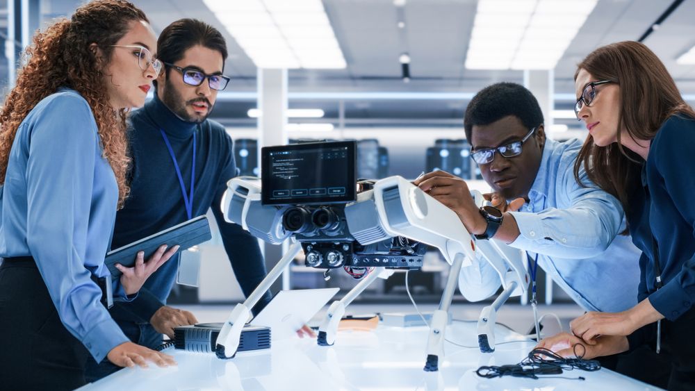 Portrait of a Young Team of Multicultural Engineers Use Computers, Insert a Circuit Board