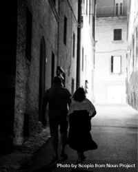 Grayscale photo of man and woman walking in an alley 4A9V84