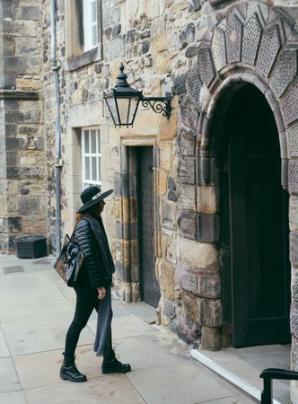 Stylish woman entering aged medieval building