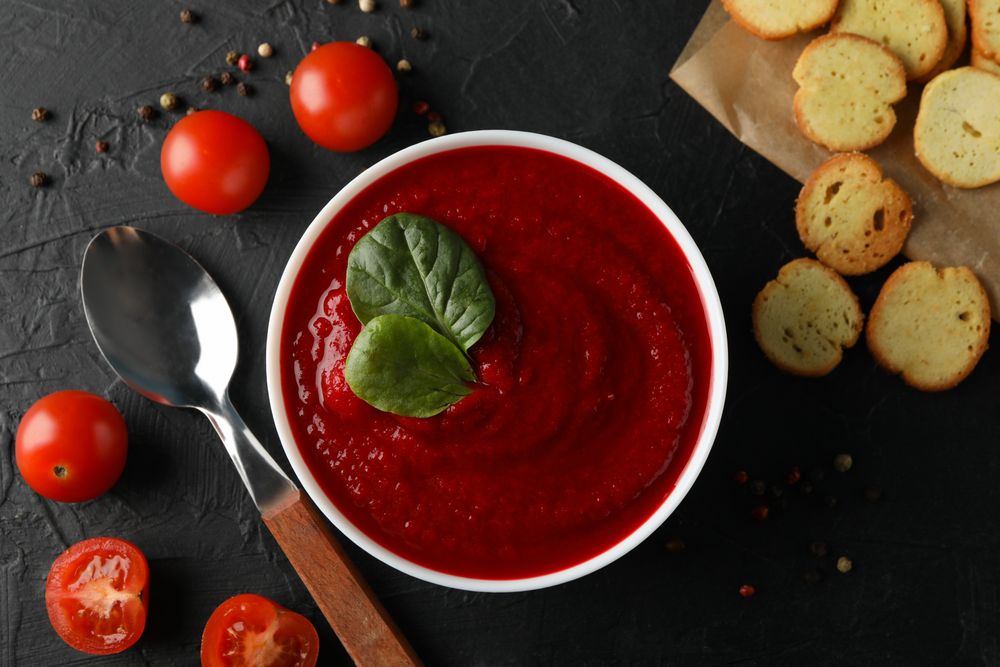 Top view of bowl of tomato soup with crackers