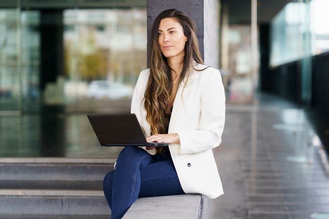 A Professional Woman Engaged in Work Using Her Laptop Within a Contemporary Office Environment