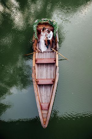 Top view of bride and groom on wooden boat