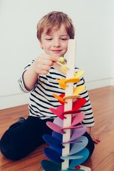 Boy playing with toy tower on floor
