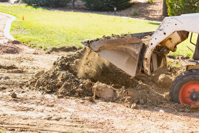 Small Bulldozer Digging In Yard For Pool Installation