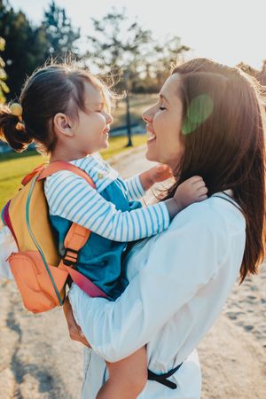Mother kissing daughter in park