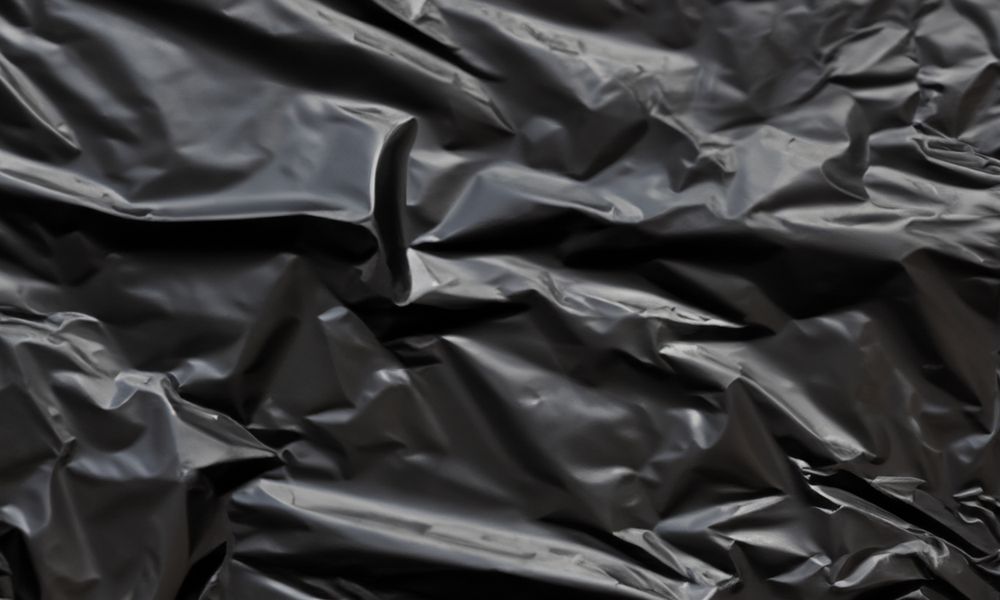 dark crumpled and creased plastic poster texture background