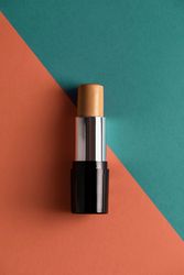 Concealer stick on modern background with geometric shapes.