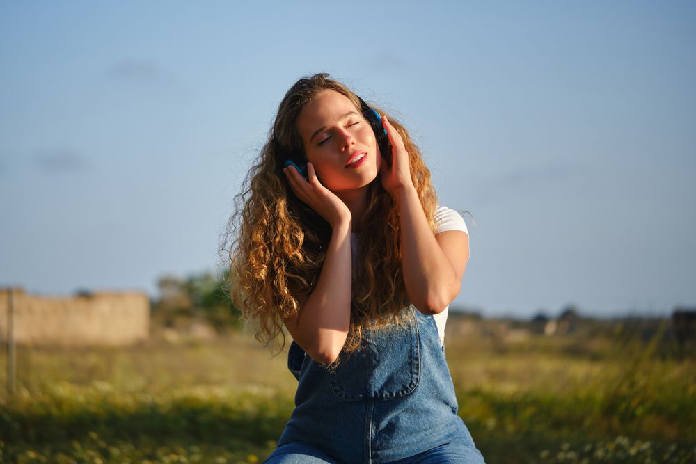 Woman listening to music via headphones in nature