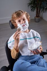 Boy shaving in a barbershop
