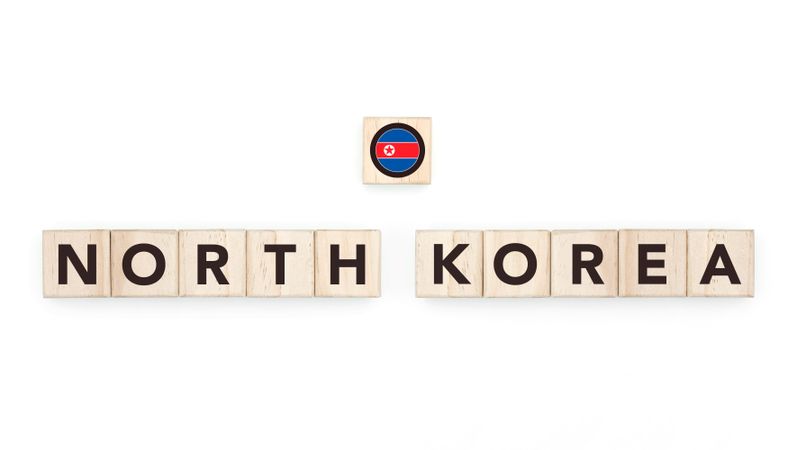 Wooden blocks bearing the name and flag of North Korea. North Korean and Asian Culture, national identity, travel, and geography in a copy space design.