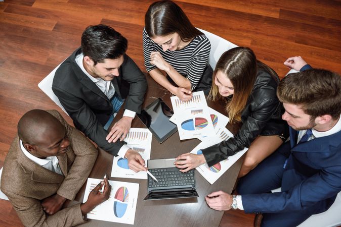 Business colleagues analyzing data together with charts and graphs