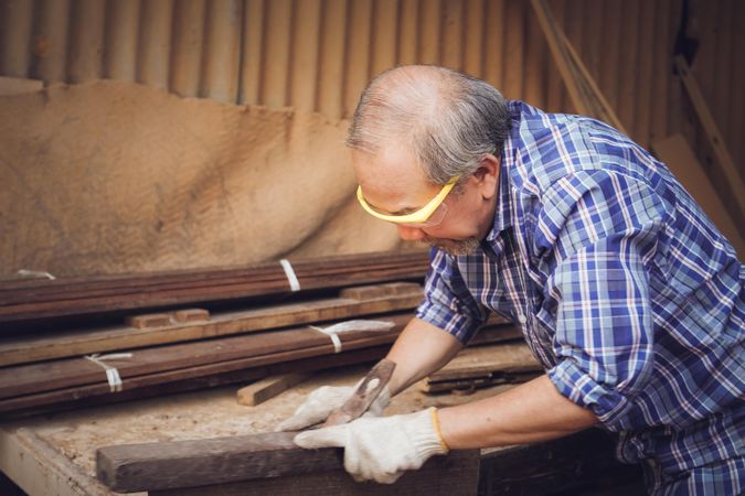 Mature Asian man working as carpenter