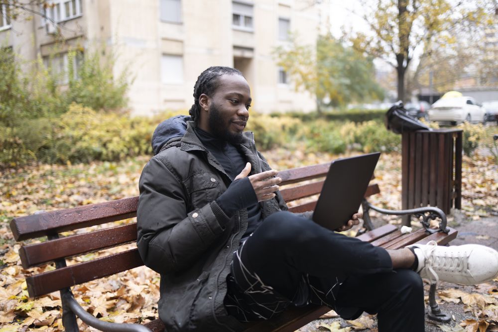 Connected Lifestyle: Young Male Engaged in Digital Dialogue Outdoors