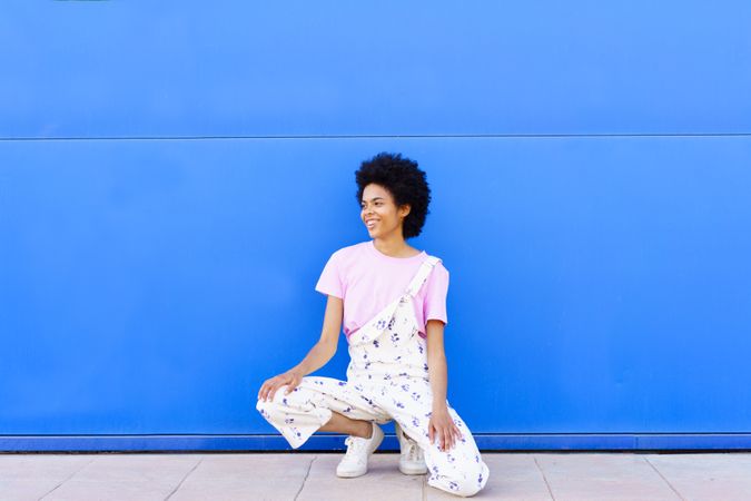 Smiling woman sitting down in front of blue building