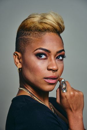 Portrait of serious Black woman with short blonde hair looking away from the camera