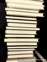 Stack of books in against dark background in grayscale 4BrJP4