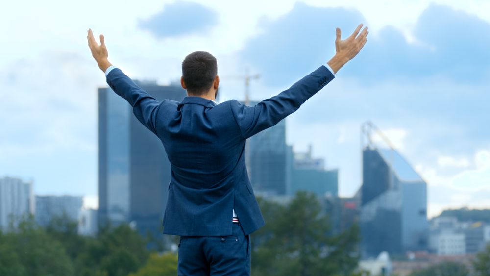 Happy Successful Business Man Raises His Hands, He Has His Business Victory.
