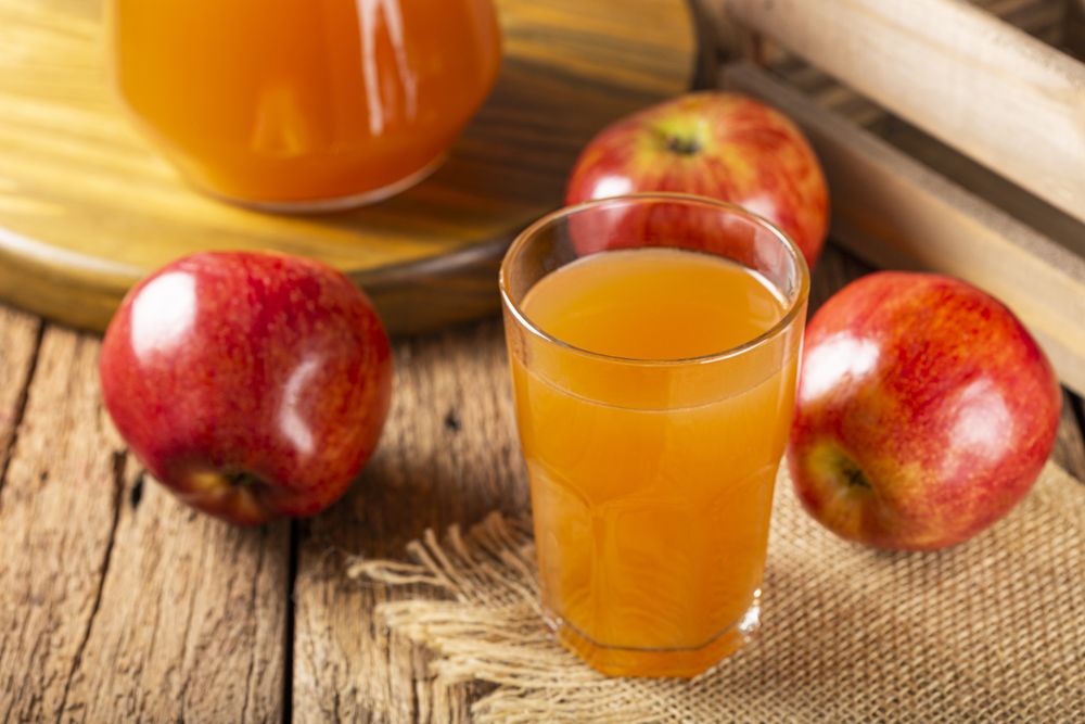 Apple juice and red apples on the table.